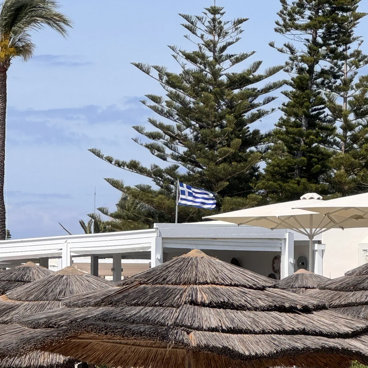 Robinson Club Kyllini Beach – Strohdach-Sonnenschirme und Flagge am Strand